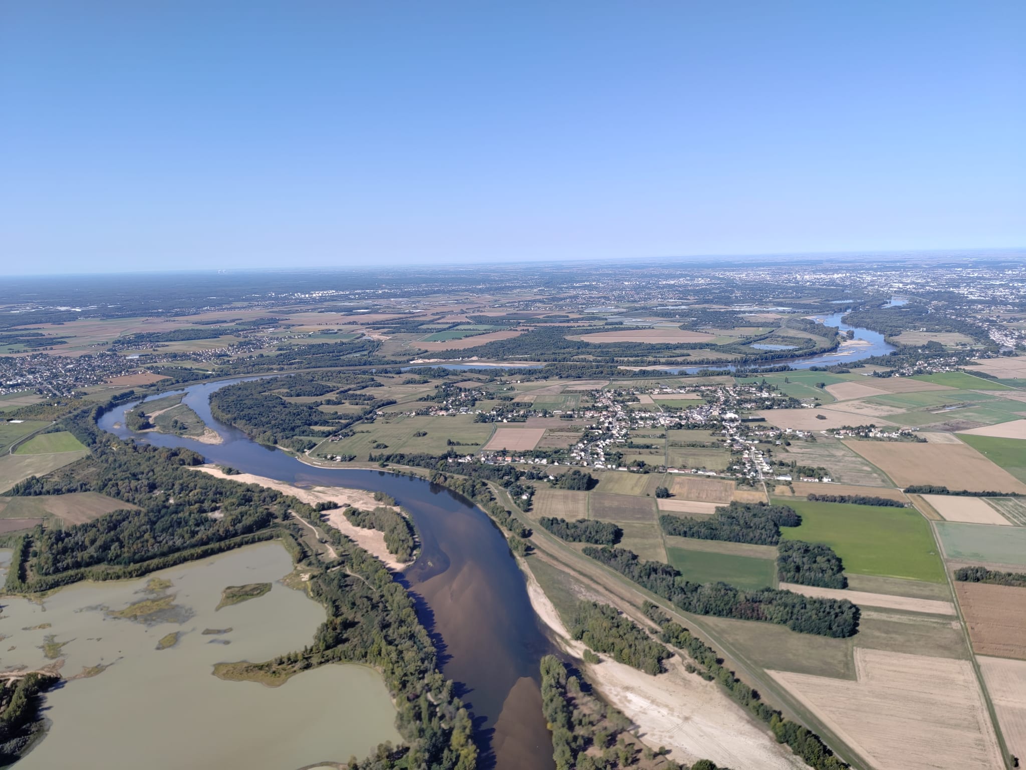 Un paramoteur survolant un paysage de la Loire